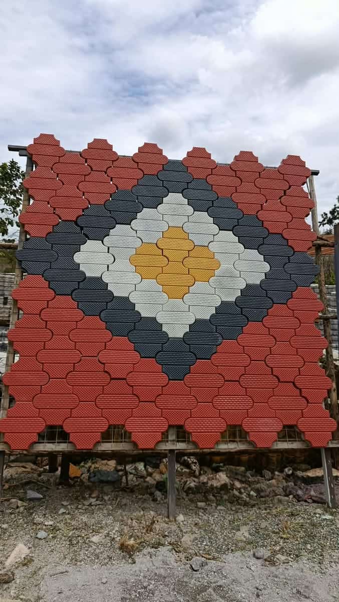 Hexagon cabro blocks in red, grey, charcoal and yellow forming a nested diamond motif on a sample panel