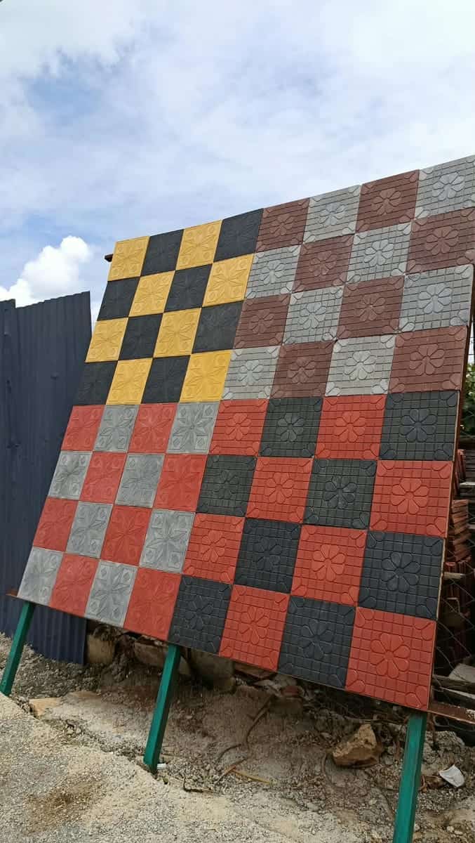 Quad square cabro blocks in red, charcoal, yellow and grey laid in a checkerboard on a yard display panel