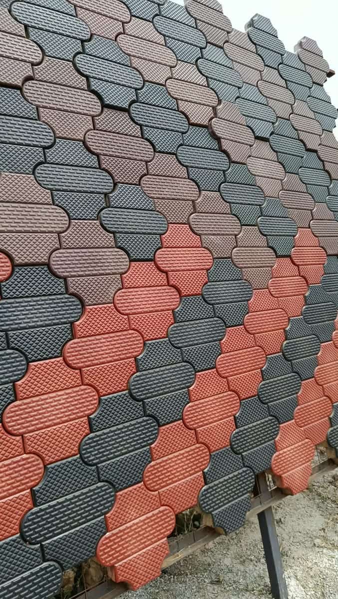 Close-up of textured red, charcoal and grey unipaver cabro blocks with a diamond-embossed face